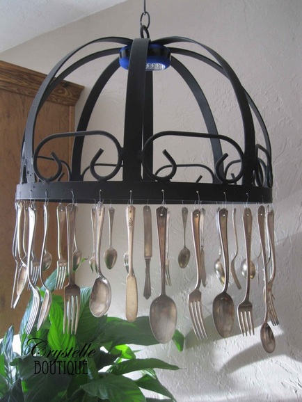 hanging silver utensils from a chandelier